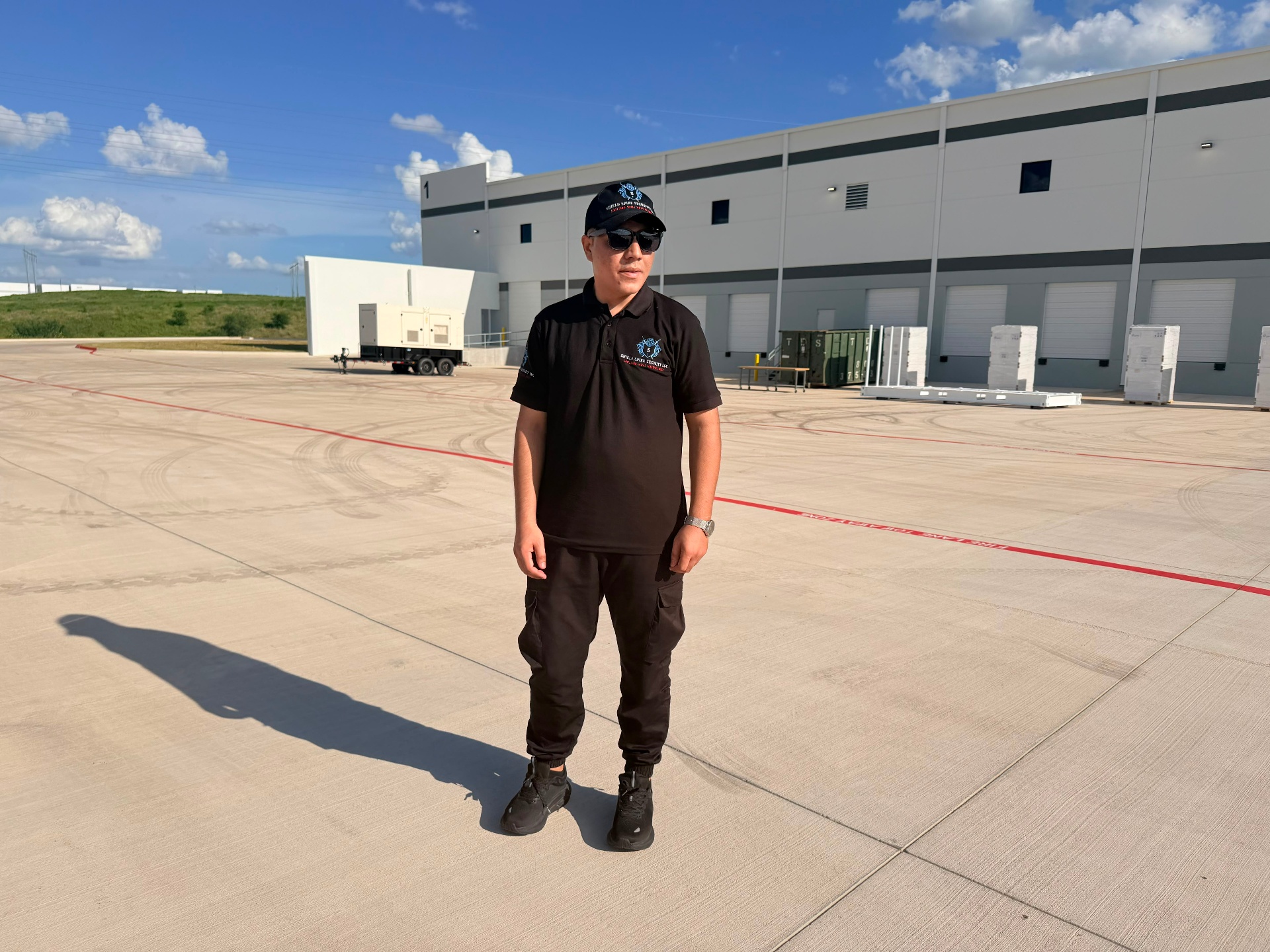 A Shield Spire security officer on post at a commercial warehouse facility during an overnight shift.