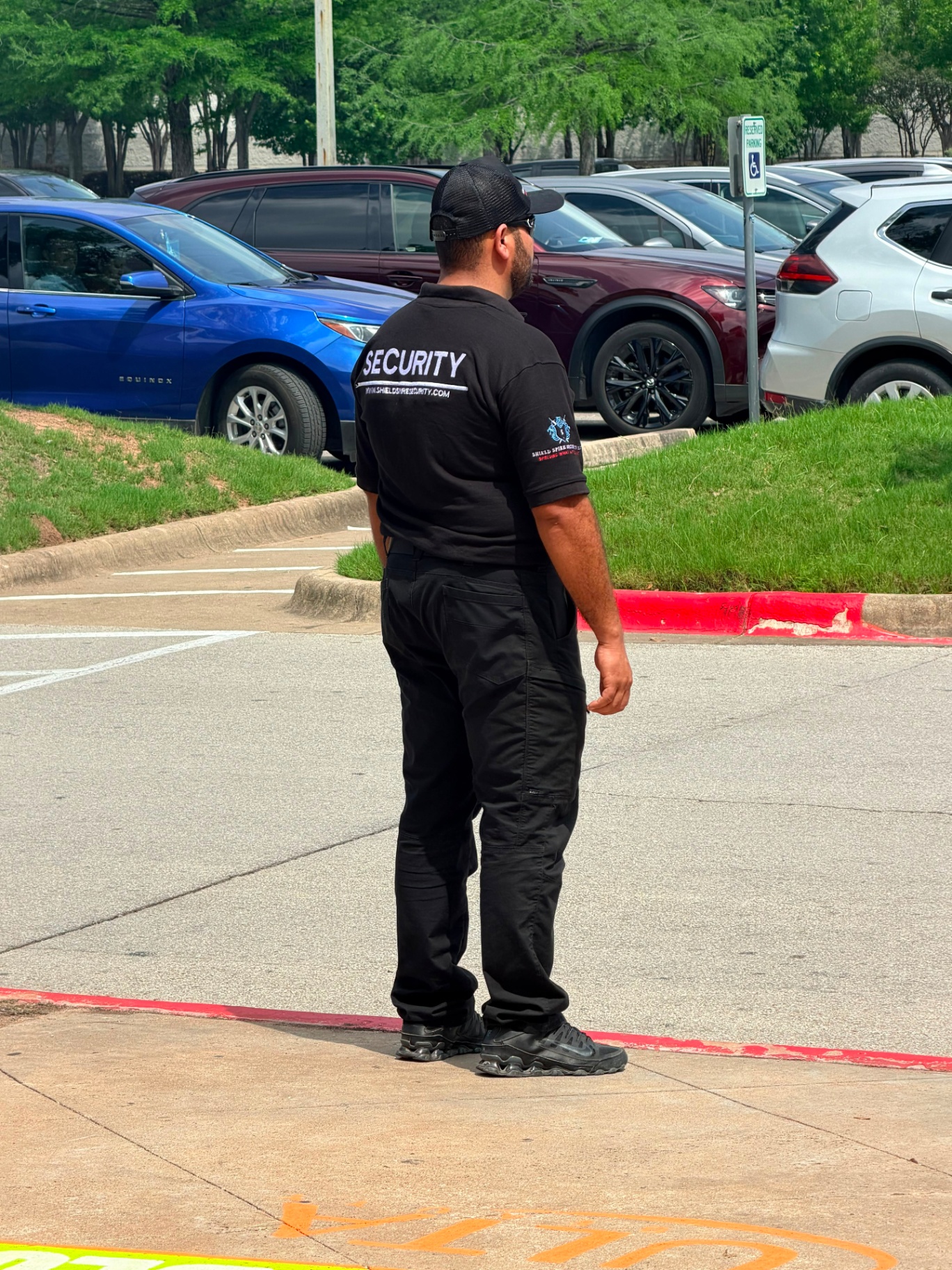 Shield Spire Security officer with SECURITY branding visible on uniform monitoring the guest arrival area at a retail promotional celebrity meet-and-greet event in South Austin, Texas.